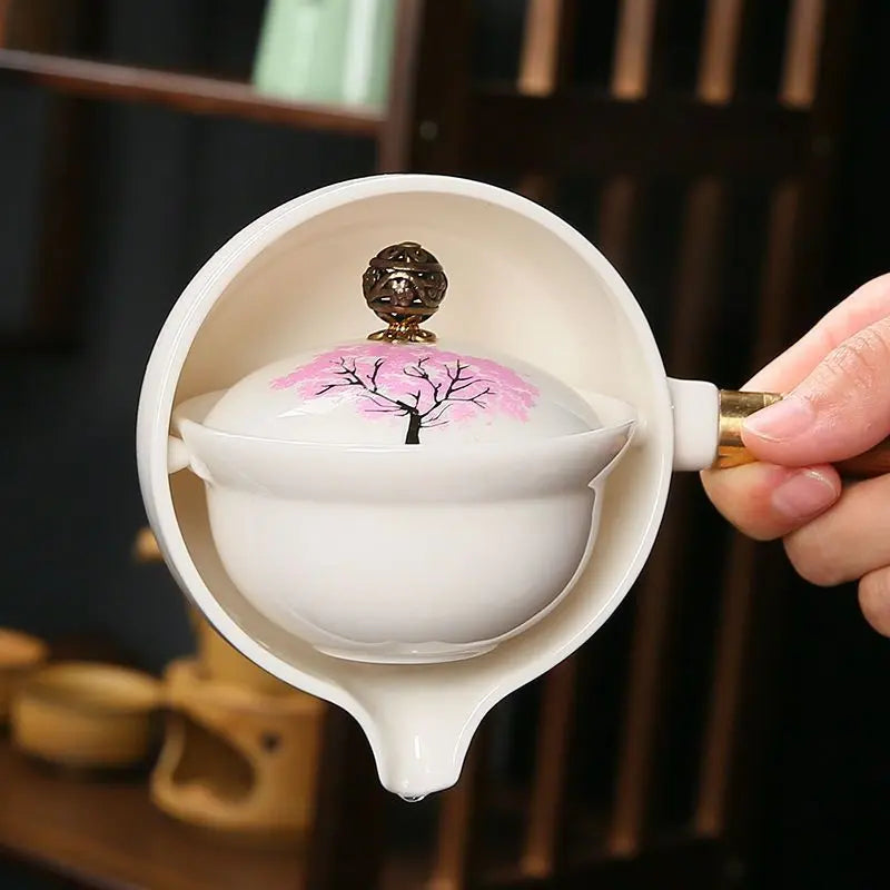 Ceramic teapot with cherry blossom decoration and rotating strainer
