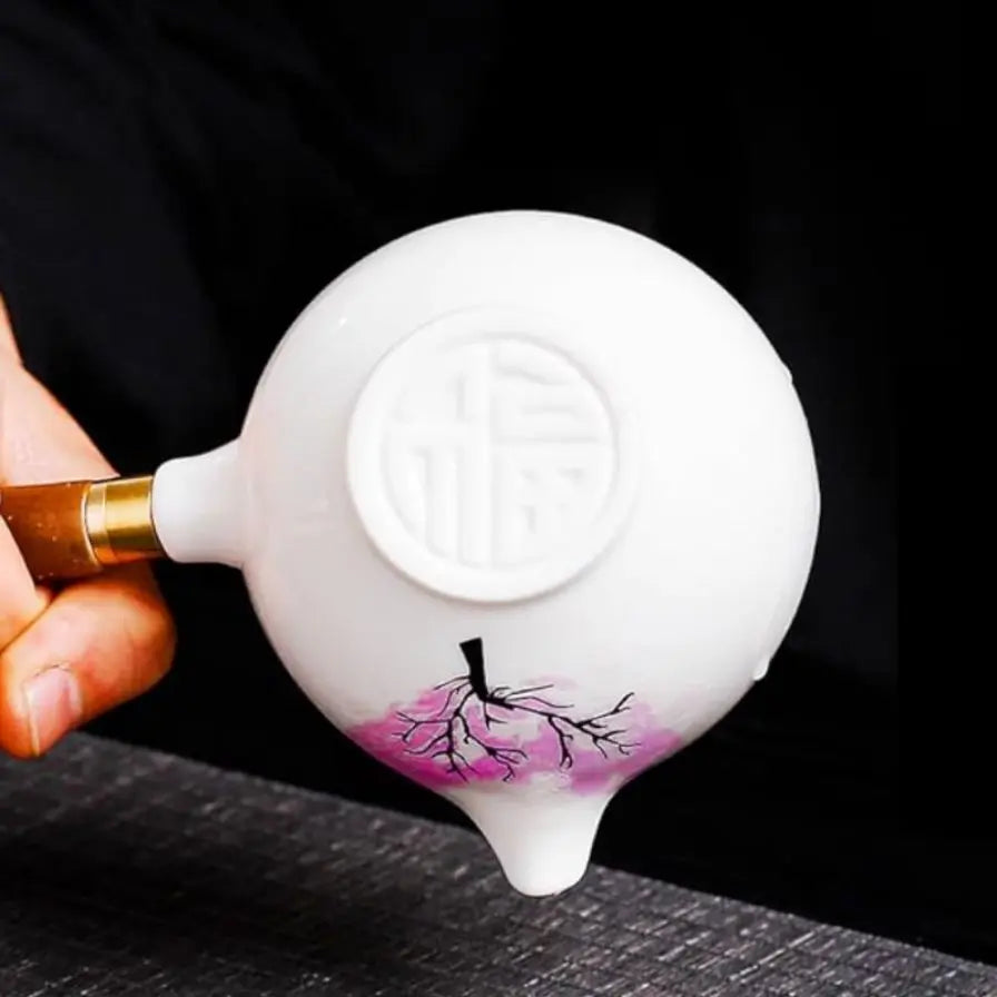 Ceramic teapot with cherry blossom decoration and rotating strainer